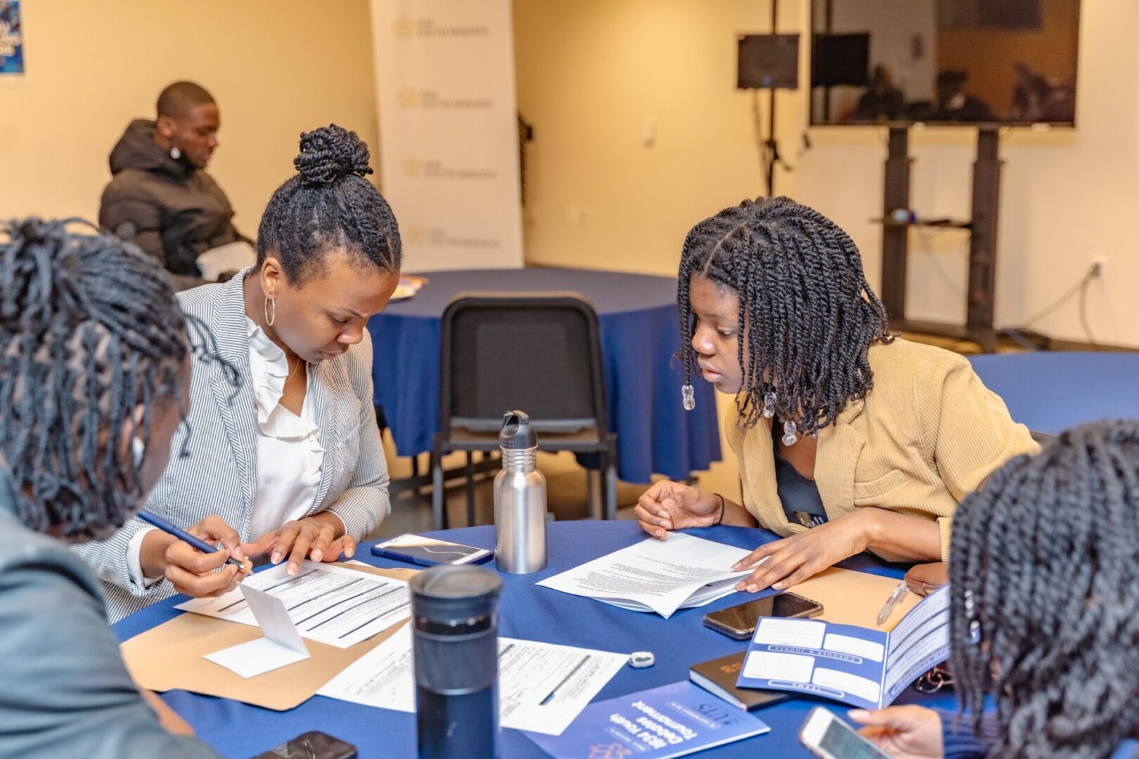 Two women collaborating over documents in a professional setting.