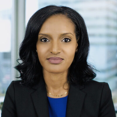 Professional woman in business attire with a confident expression.